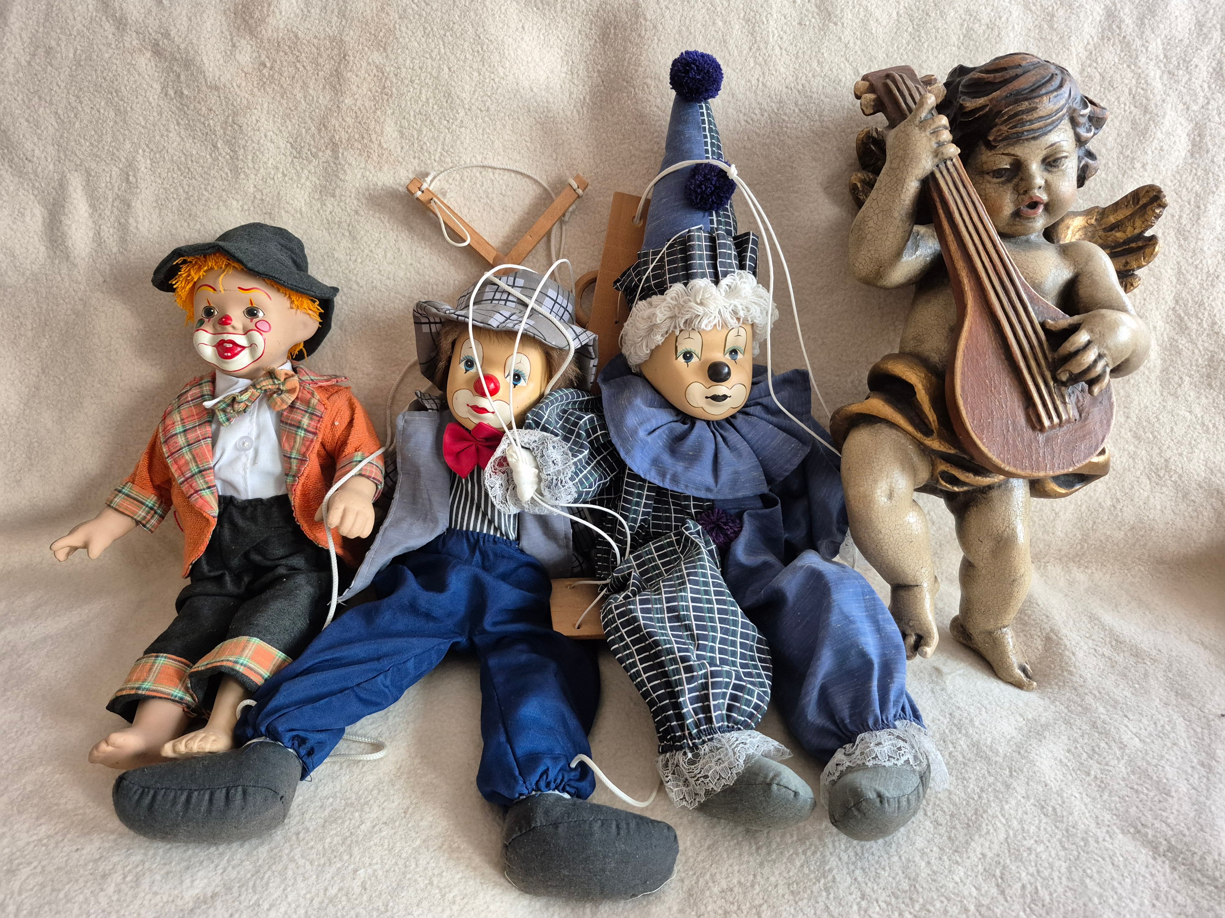 Drei Clown-Puppen und eine Engelsfigur